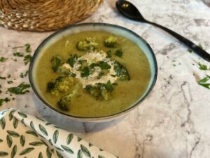A bowl of broccoli soup with parsley and vegan cream on top,demonstrating how to fix bland broccoli soup