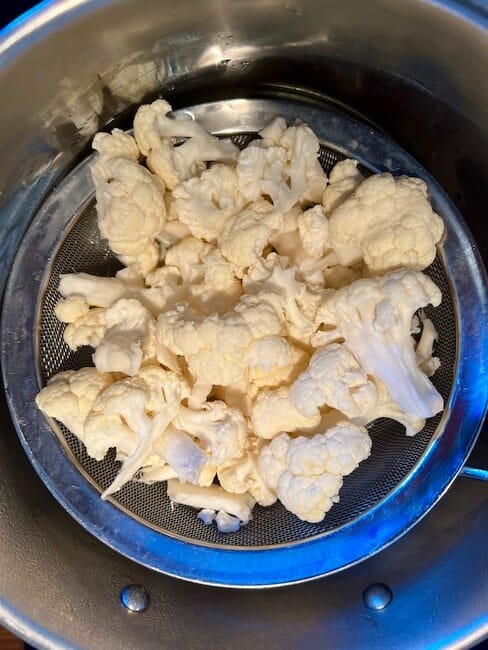 Cauliflower in a sieve for steaming