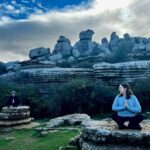 Meditation with or without music: two people sitting on rocks meditating