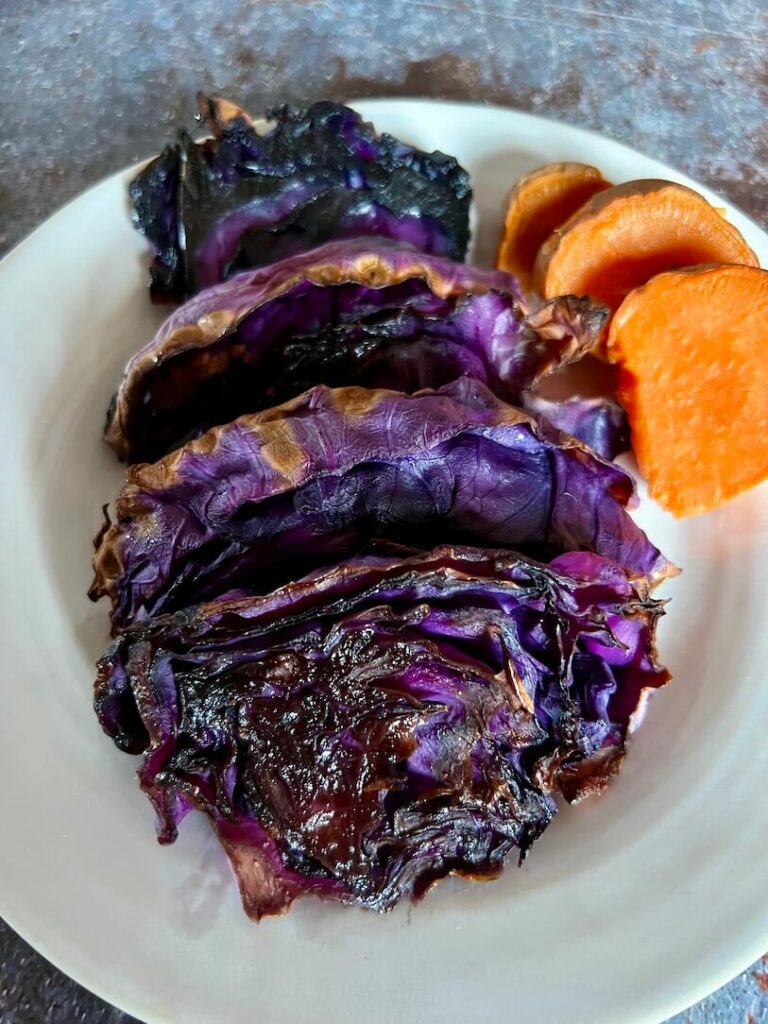 What's you favourite way to eat cabbage? Roasted purple cabbage on a plate with sliced sweet potato