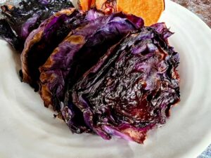 What's your favourite way to eat cabbage? Roasted purple cabbage on a plate with sweet potato slices