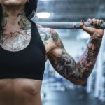 Does OMAD cause muscle loss? Image of the left arm of a female weightlifter covered in tattoes