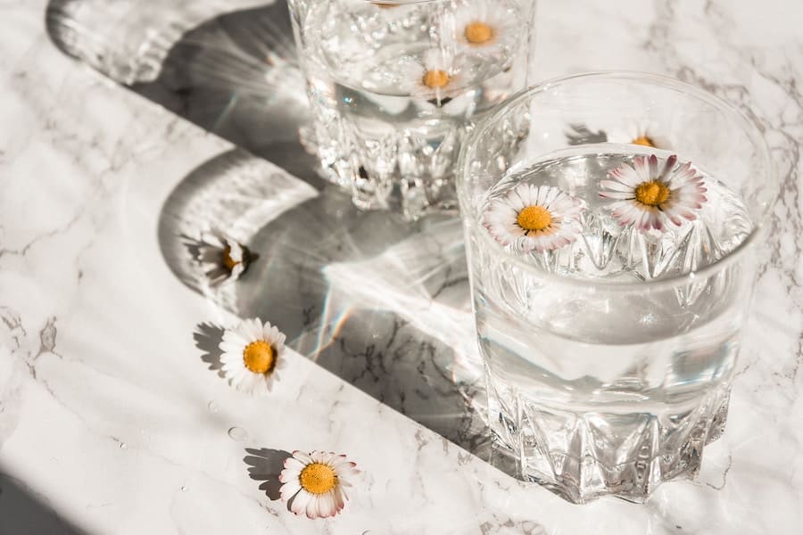 Two glasses of water with flowers floating in the water - the role of water on an OMAD diet