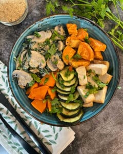 Vegan creamy garlic mushrooms in a vegan bowl with sweet potato, tofu, courgette and pumpkin slices