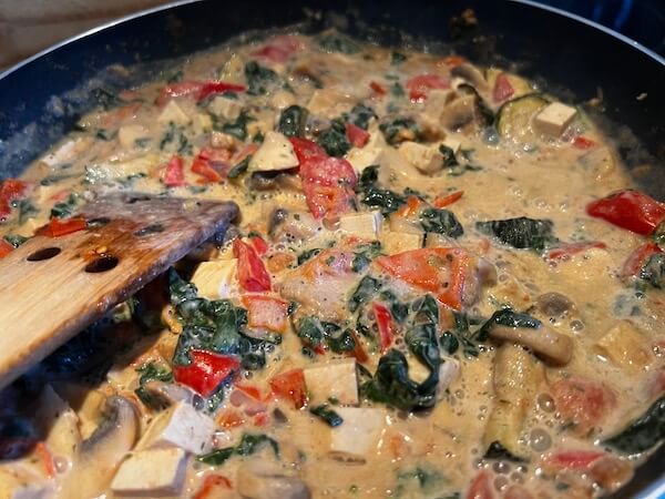 Cooking mushrooms, red pepper, tomato, spinach and courgette for WFPB creamy mushroom pasta