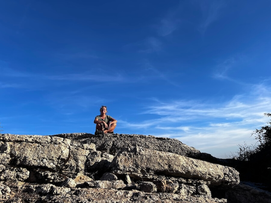 Sitting on top of a rock with blue skies behind as part of how I normalised my tinnitus
